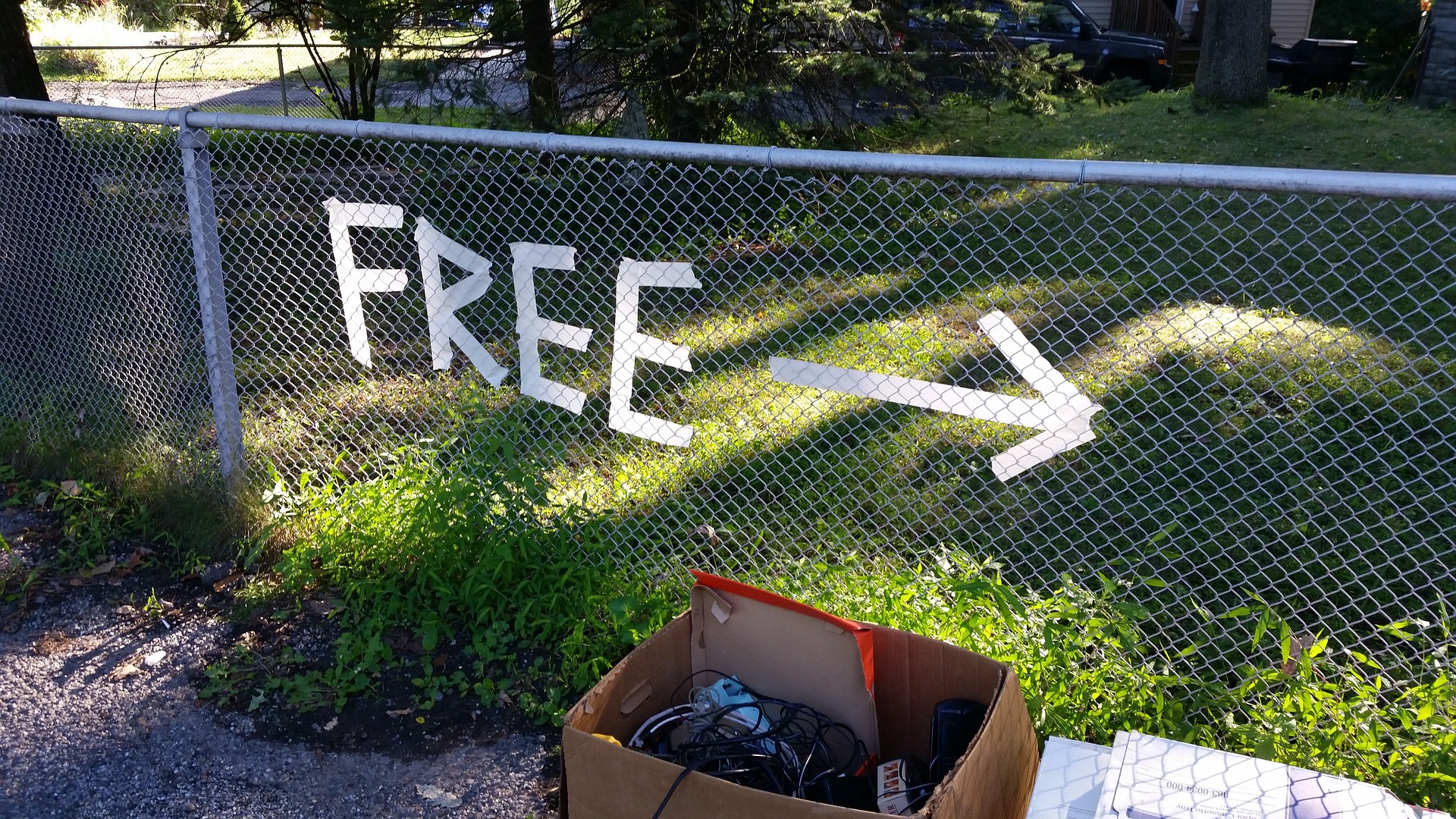 image of left over stuff in a box from a garage sale under a Free sign